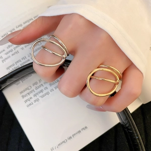 Macro shot of minimalist gold and silver double-layered geometric rings on fingers