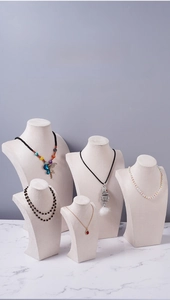 Velvet necklace bust display set in different heights on marble surface for jewelry shops