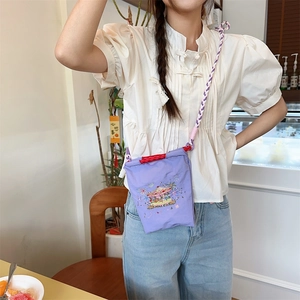 Close-up of purple oxford bag with colorful carousel embroidery and woven strap
