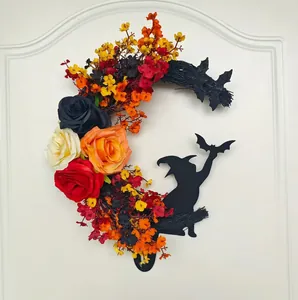 Detail of Halloween crescent wreath with roses and witch silhouettes on a white door