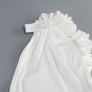 Détail du décolleté blanc à volants et de la fermeture à double bouton dans le dos