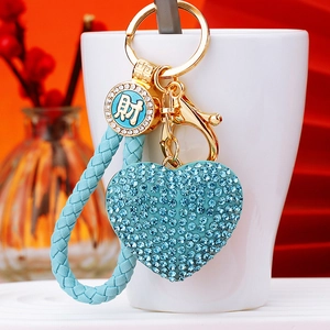 Blue rhinestone heart keychain with gold hardware and braided rope detail close-up