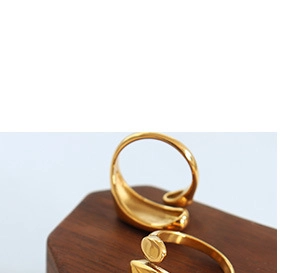 Detailed view of two minimalist 18k gold-plated adjustable rings on a wooden stand