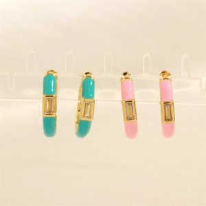 Detail of candy color enamel hoop earrings with rectangular zircon on a clear display