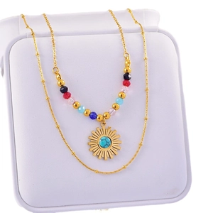 Bohemian double-layer necklace with gold sun pendant and colorful beads on a box