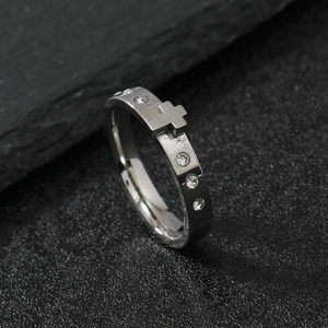 Polished stainless steel cross ring with crystal inlays on natural stone background