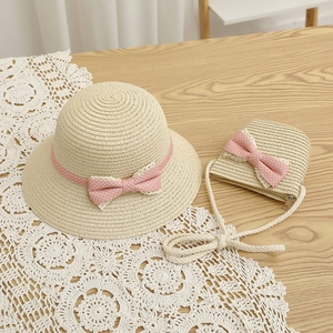 Detail of kids straw sun hat and matching crossbody bag with pink polka dot bows and lace