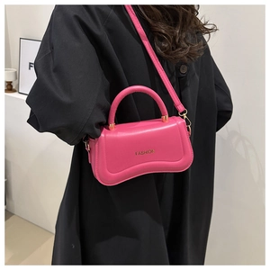 Gros plan d'un sac bandoulière rose en cuir avec lettrage Fashion doré et anse ronde