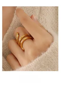 Detailed view of a gold snake-shaped wrap ring with scale textures and black eye accents