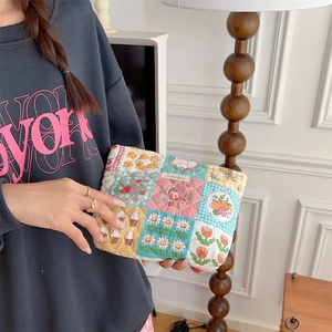Close-up of quilted cotton makeup bag featuring mixed cartoon floral and strawberry patterns