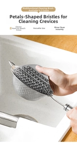 Detail of grey petal-shaped silicone brush cleaning a fine mesh stainless steel sieve