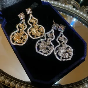 Elegant 18K gold and silver gourd earrings with floral hollow design and crystal inlay