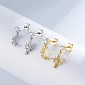 Macro detail of asymmetric star and moon drop earrings with sparkling cubic zirconia stones