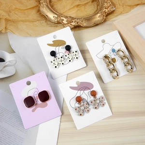 Flat lay of artistic jewelry display cards with assorted stud earrings on vintage background