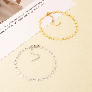 Détail de bracelets de cheville réglables en or et argent avec de petits sequins ronds