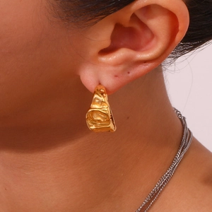 Detailed view of 18K gold plated crescent earrings with lava textured molten finish