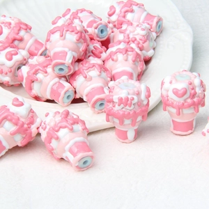 Macro detail of hand-painted ice cream acrylic beads in pink and white for DIY crafts