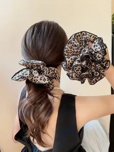 Dettaglio di elastici per capelli leopardati oversize con bordi neri e trama satinata