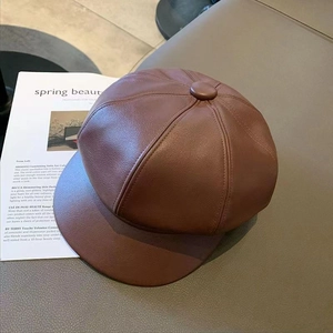 Detailed top view of dark brown faux leather beret hat showing premium grain texture