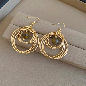 Vintage gold-plated multi-ring earrings with round tiger eye stones on jewelry box