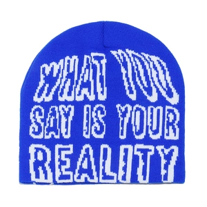 Close-up of blue knit beanie featuring white jacquard text and street style texture