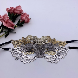 Close-up of gold and silver lace embroidery masquerade masks with black ribbons