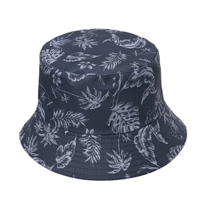 Close-up of tropical palm leaf print and reinforced stitching on a navy bucket hat