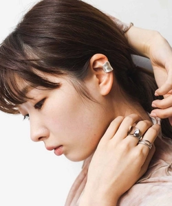Nahaufnahme von minimalistischem mattem Silber-Ohrmanschetten- und Ring-Set an Model