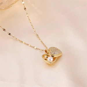 Elegant gold heart locket necklace with pearls and zircon on champagne silk fabric