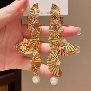 Detail of gold fan-shaped tiered tassel earrings with white pearls and S925 silver posts