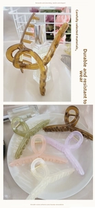 Detail view of large matte hair claws in various soft colors with spiral design