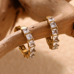 Créoles minimalistes plaquées or 18 carats avec zircons carrés sur une branche en bois