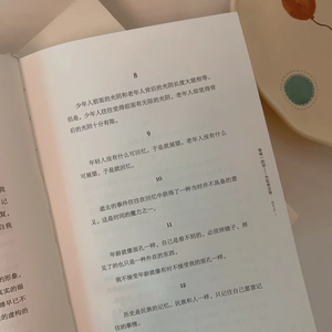 Close-up of printed Chinese prose pages inside a floral cotton bag with soft lighting