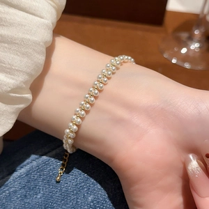 Close-up of double-layer pearl bracelet with gold beads and adjustable chain on wrist