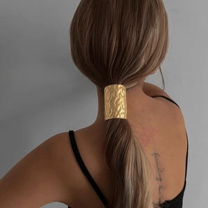 Minimalist gold metal hair tie with hand-hammered texture for low ponytail styles