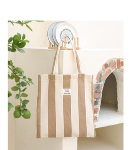 Detailed macro view of the textured vertical stripes and branding on the canvas tote bag