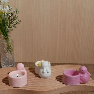 Macro detail of cute rabbit ceramic candle holders on a natural wooden tray