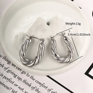Primo piano di orecchini a cerchio intrecciati a U in argento con diametro 2,6 cm e peso 13 g