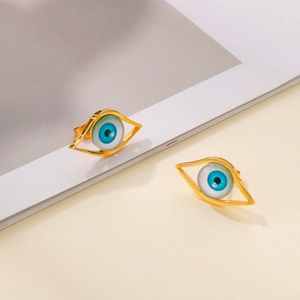 Detail of gold evil eye stud earrings with vibrant blue resin center on neutral background