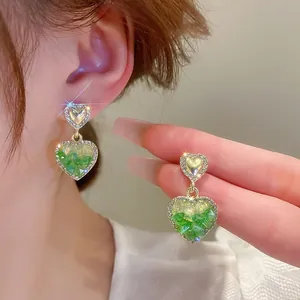 Detailed close-up of gradient crystal double heart drop earrings with rhinestone edges