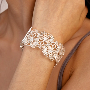 Detailed view of matte silver hollow floral geometric link bracelet on model wrist