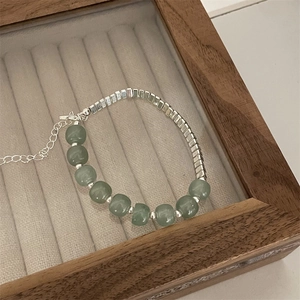 Detail of beaded bracelet with turquoise stones and silver metal cubes in a jewelry box