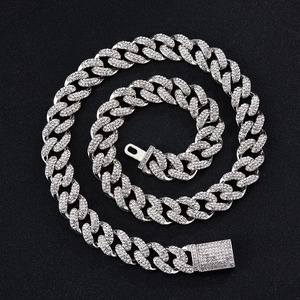 Close-up of silver Cuban link necklace with rhinestones and 18KGP engraving on the clasp