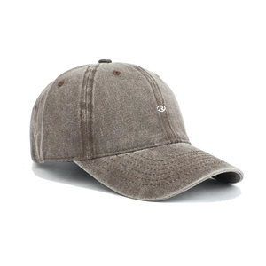 Detailed close-up of a washed cotton baseball cap featuring vintage fabric and white embroidery