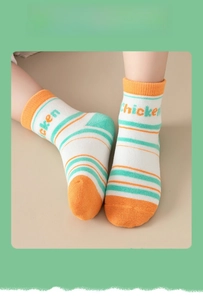Detail of white cotton baby socks with orange stripes and Chicken knitted lettering