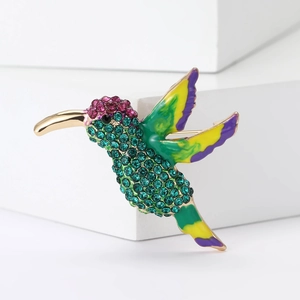 Detailed view of hummingbird brooch with colorful rhinestones and enamel on gold alloy