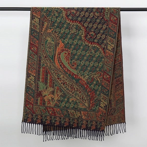 Close-up of woven paisley scarf with fringes in deep green, red and gold silk blend