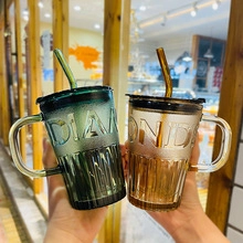 Gros plan de mugs en verre nervuré vert et ambre avec paille et relief Diamond élégant