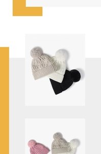 Detailed view of chunky cable knit winter beanies with large faux fur pom poms and soft lining