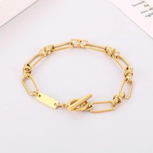 Detail of gold chain necklace with toggle clasp and minimalist rectangular metal pendant tag